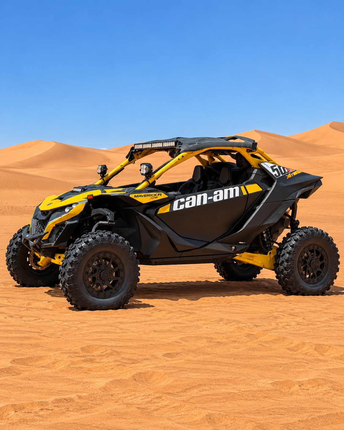 Profil du Can-Am Maverick R jaune et noir posé sur le sable